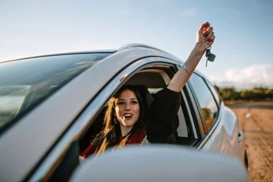 happy woman in car showing keys