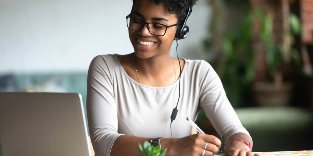 smiling woman with headphones and laptop