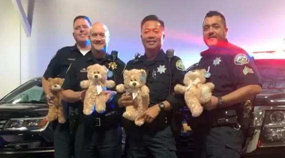 police officers holding teddy bears